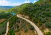 Group riding electric bikes through green hills and rural roads near Berat on the way to Roshnik.